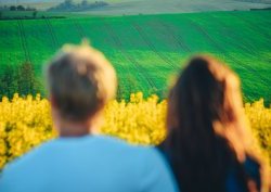 זוג צופה בשדה ירוק ופרחים צהובים